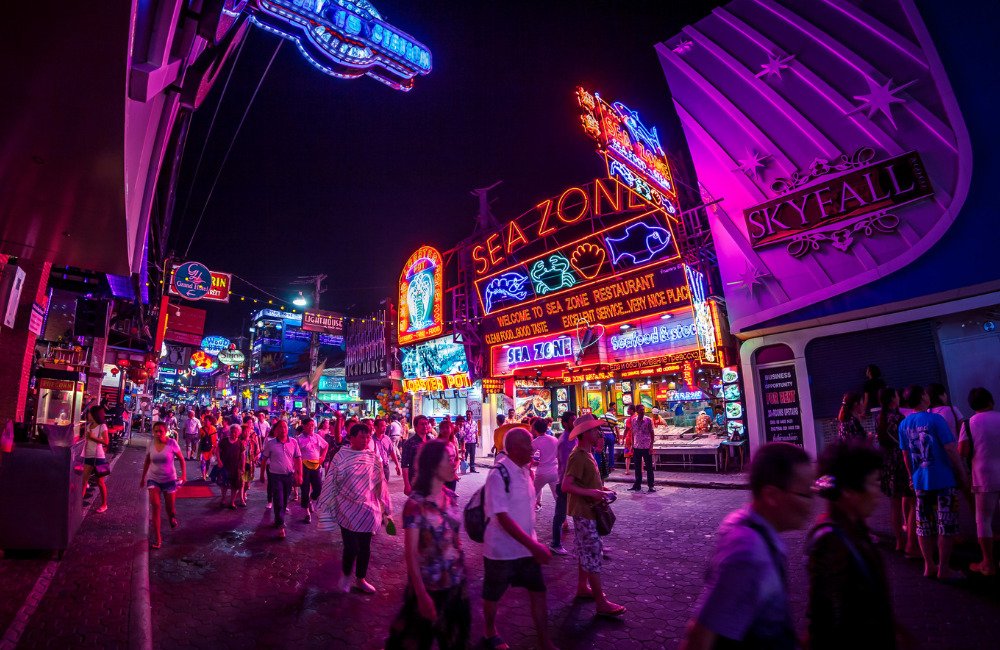 Vibrant night scene of Pattaya Walking Street with neon signs, restaurants, and crowds of visitors—capturing the energetic nightlife atmosphere near Altera Hotel and Residence.