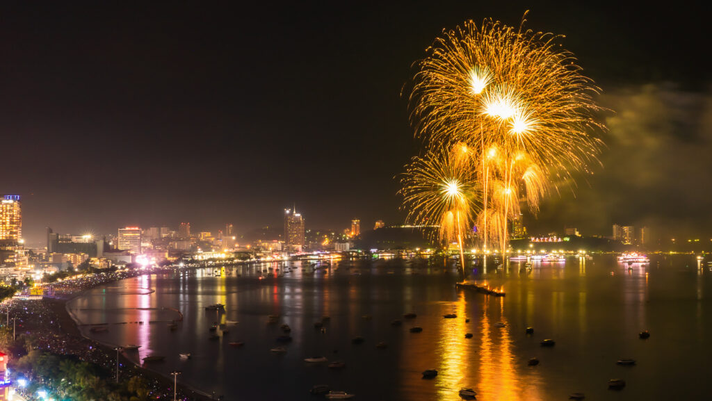 Golden fireworks lighting up Pattaya Bay with city lights and dining venues during the Pattaya Fireworks Festival 2025.