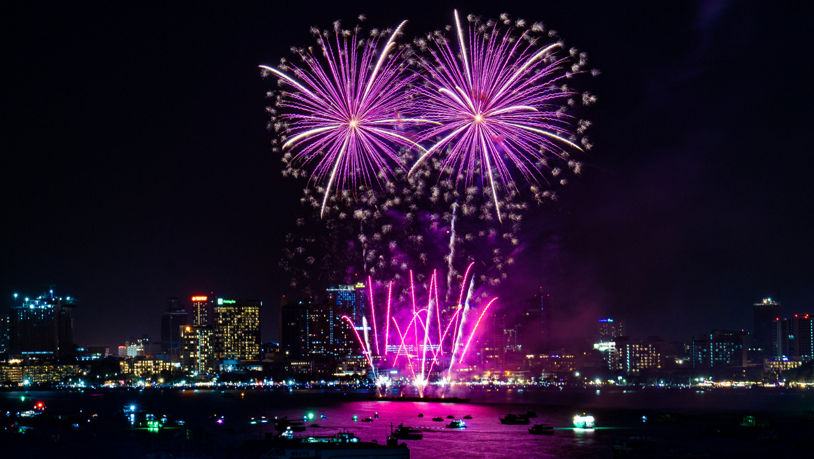 Purple fireworks over Pattaya Bay with city skyline and nightlife, highlighting things to do before and after the Pattaya Fireworks Festival 2025.