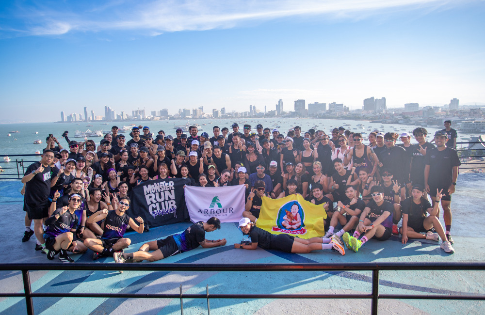 Group photo of Arbour Run Club, MONSTER.RUNBKK, and event partners at Pattaya Beach Run 2025, celebrating the growing wellness community in Pattaya with a stunning sea view backdrop.
