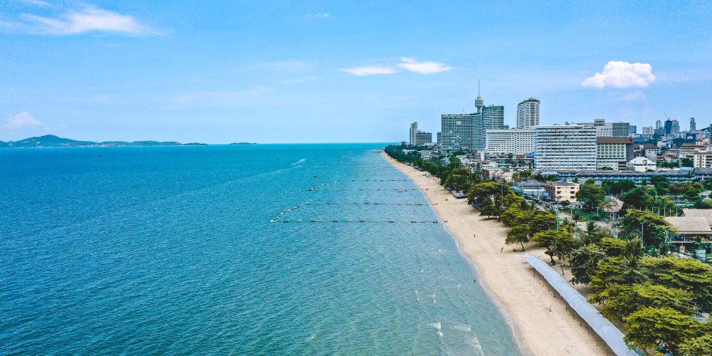 Aerial view of Pattaya Beach with clear blue water and cityscape, located near Arden Hotel and Residence Pattaya.