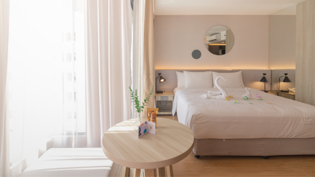 Deluxe room at Aster Hotel and Residence Pattaya with king bed, swan towel decoration, and modern interior design