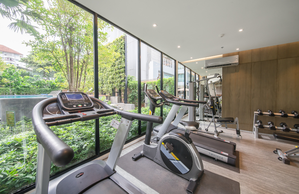 Fitness center at Hotel Amber Pattaya with modern equipment and garden view, ideal for weekend travelers.