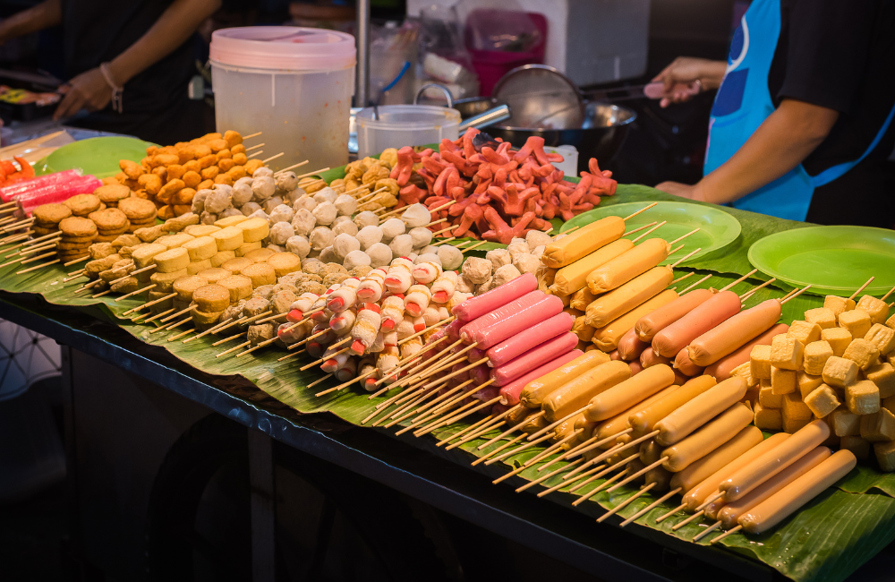 Colorful Thai street food skewers at a local market near Hotel Amber Pattaya, offering authentic flavors for travelers.