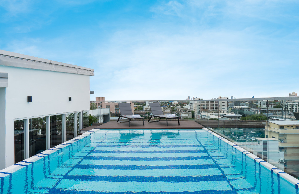 Rooftop swimming pool at Hotel Amber Sukhumvit 85 overlooking Bangkok city skyline