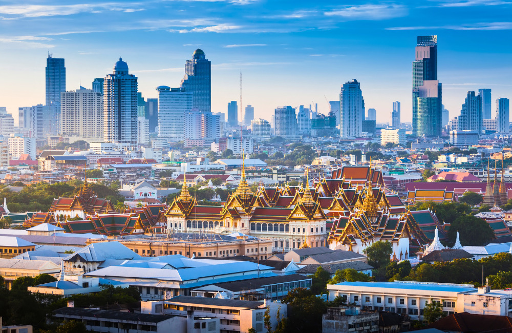 Grand Palace Bangkok with golden rooftops and tourists walking