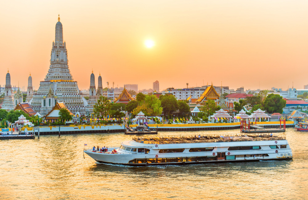 Wat Arun Temple of Dawn by Chao Phraya River at sunset