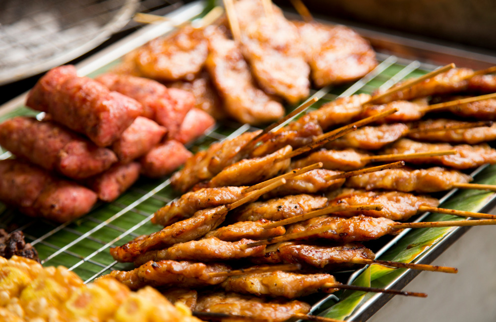 Street food vendor grilling skewers at Sukhumvit Soi 85