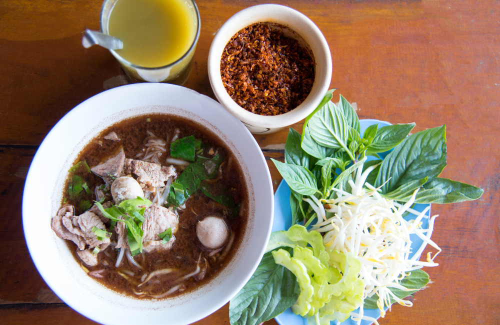 Boat noodle stall with steaming bowls in Phra Khanong
