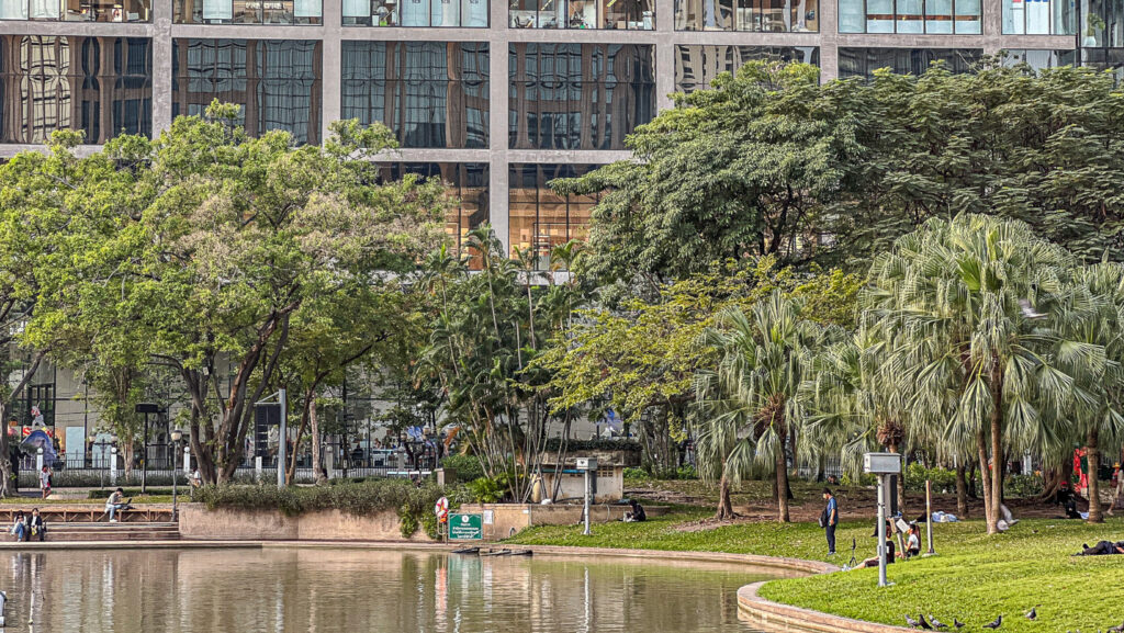 Benjasiri Park Bangkok lakeside with palm trees and people relaxing near Emporium Mall
