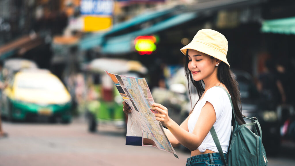 Traveler exploring Khaosan Road Bangkok with a map during the day