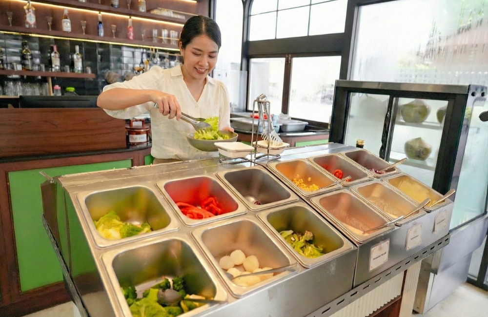 ลูกค้ากำลังเลือกตักผักสดที่สลัดบาร์ในบุฟเฟต์อาหารเช้า 159 บาท โรงแรมแอมเบอร์ 85