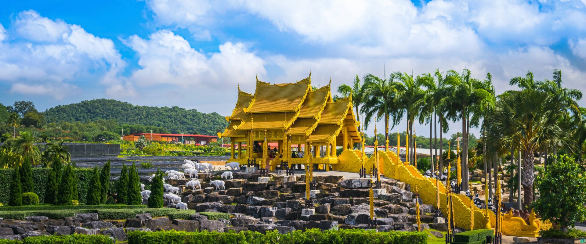 ศาลาทรงไทยสีทองในสวนนงนุช พัทยา รายล้อมด้วยสวนไม้ตัดแต่งสวยงามและต้นปาล์ม บรรยากาศสดใสท่ามกลางท้องฟ้าสีคราม