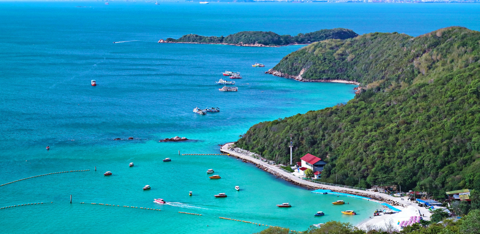 Panoramic sea view of Koh Larn Island with turquoise water, green hills and boats near Pattaya