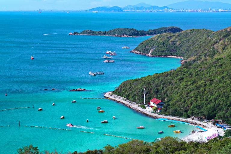 Panoramic sea view of Koh Larn Island with turquoise water, green hills and boats near Pattaya