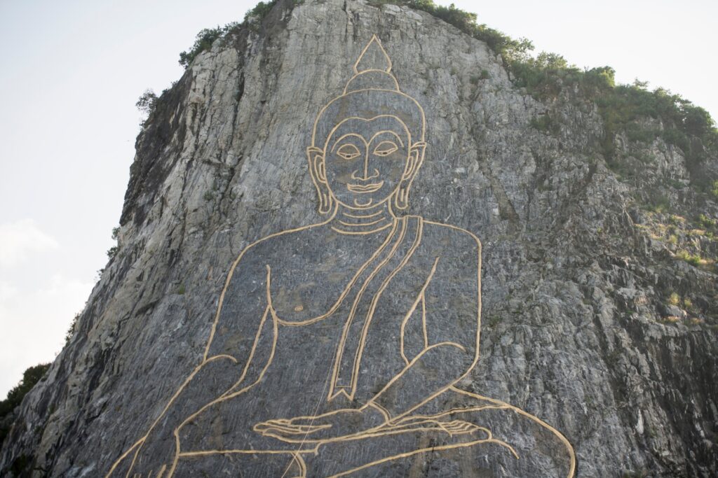 Close-up of the golden Buddha engraving at Khao Chi Chan Pattaya, outlined across the steep limestone face of the famous Buddha Mountain.